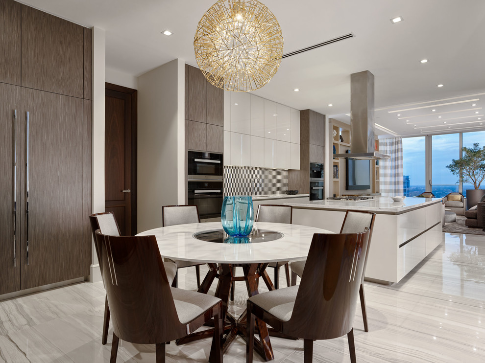 Contemporary open plan kitchen in Miami with flat-panel cabinets, white cabinets, multi-coloured splashback, black appliances, with island, white floor, white benchtop and marble floors.