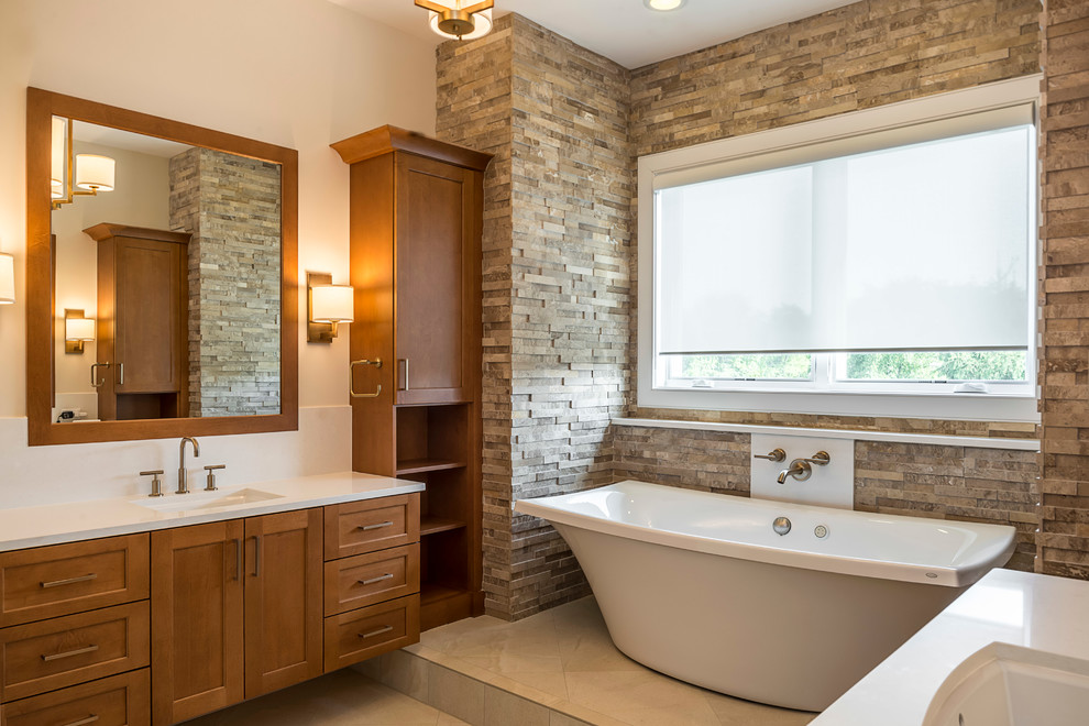 Inspiration for a mid-sized transitional master bathroom in Chicago with shaker cabinets, medium wood cabinets, a freestanding tub, an open shower, a bidet, beige tile, stone tile, beige walls, porcelain floors, an undermount sink and engineered quartz benchtops.