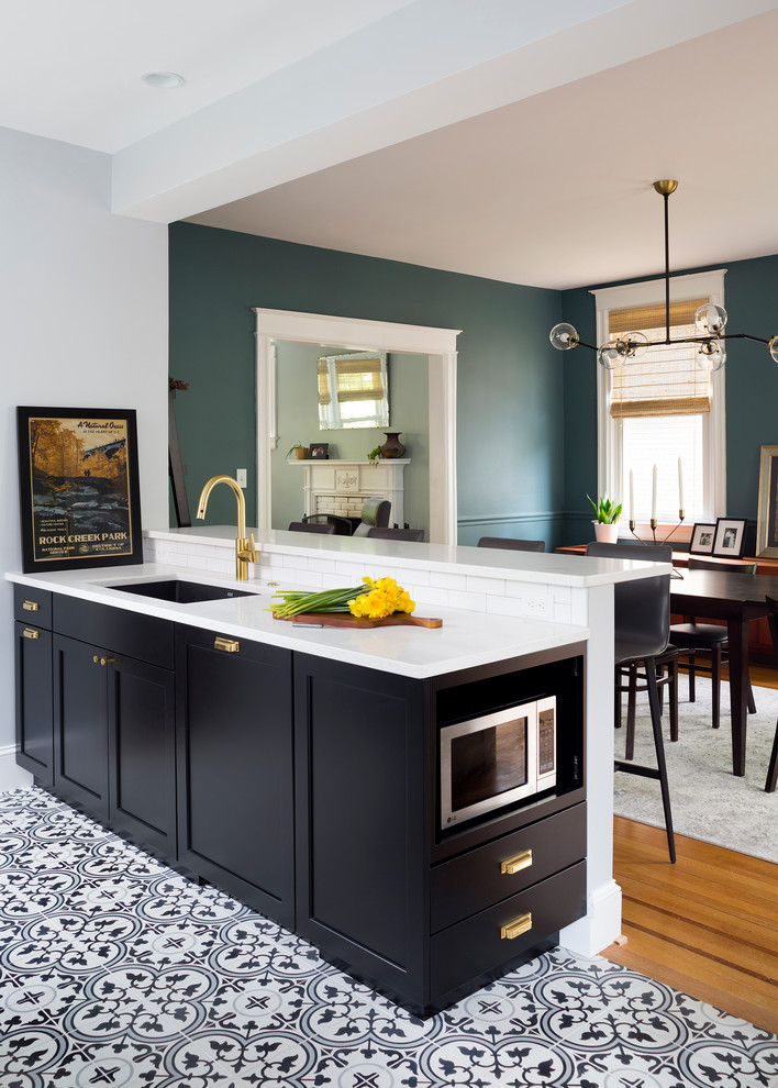 Mid-sized transitional black floor eat-in kitchen photo in DC Metro with black cabinets, white backsplash, subway tile backsplash and stainless steel appliances