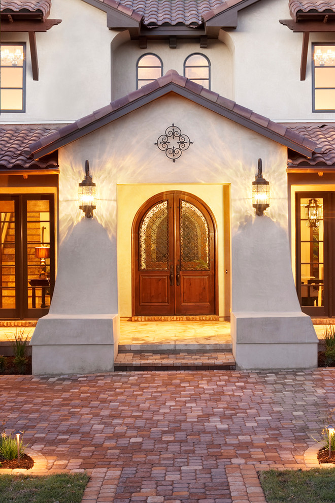 Photo of an expansive mediterranean two-storey stucco white house exterior in Austin with a gable roof and a tile roof.