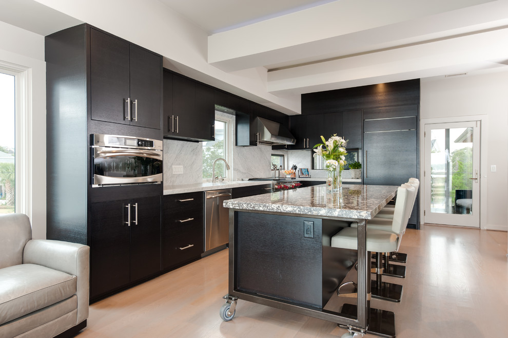 Example of a large l-shaped light wood floor enclosed kitchen design in Orange County with an undermount sink, flat-panel cabinets, dark wood cabinets, marble countertops, multicolored backsplash, stone slab backsplash, stainless steel appliances and an island