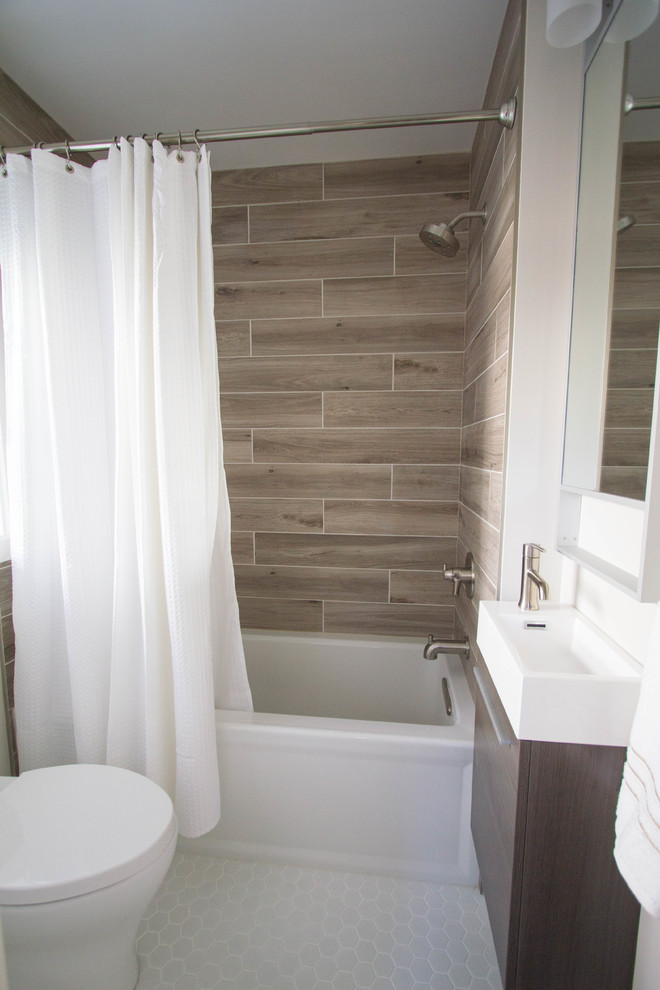 This is an example of a small transitional 3/4 bathroom in Philadelphia with flat-panel cabinets, dark wood cabinets, an alcove tub, a two-piece toilet, brown tile, porcelain tile, beige walls, porcelain floors, a wall-mount sink, solid surface benchtops, white floor and a shower curtain.