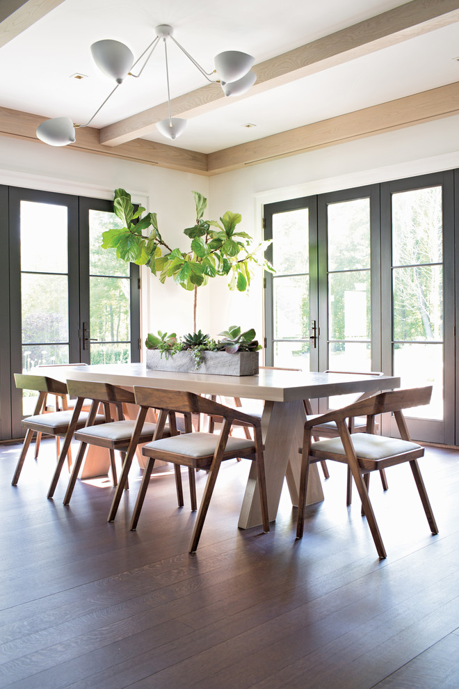 This is an example of a mid-sized transitional open plan dining in New York with no fireplace, white walls, dark hardwood floors and brown floor.