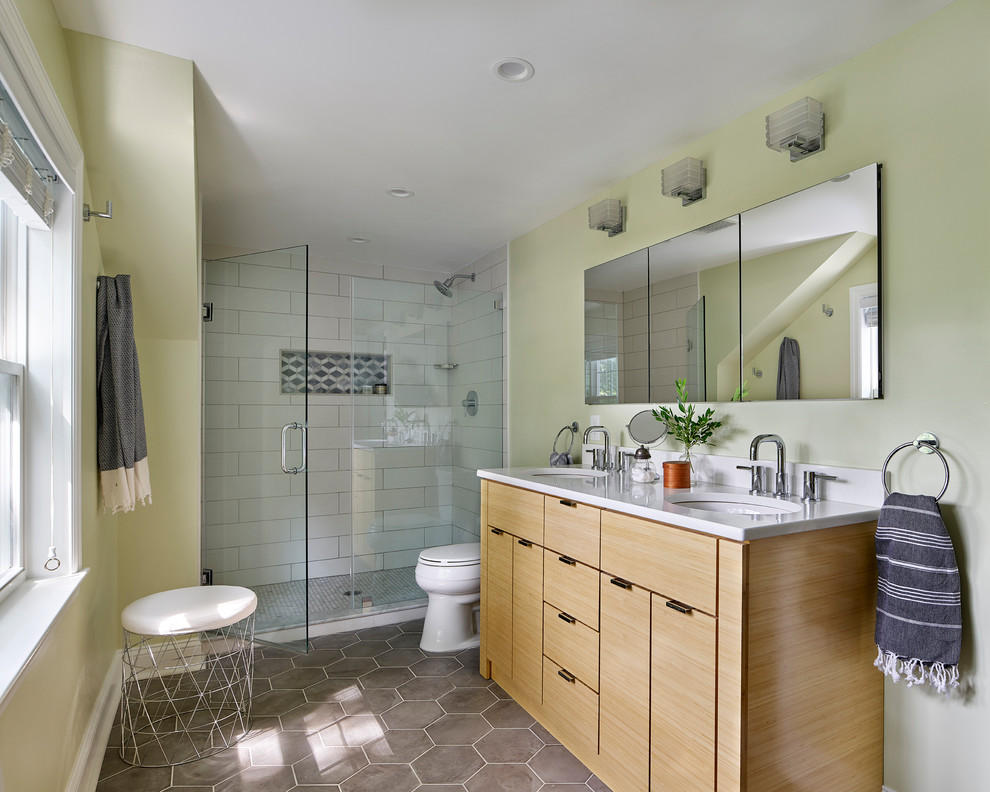 This is an example of a mid-sized contemporary master bathroom in Philadelphia with flat-panel cabinets, light wood cabinets, an alcove shower, white tile, porcelain tile, green walls, porcelain floors, an undermount sink, grey floor and a hinged shower door.