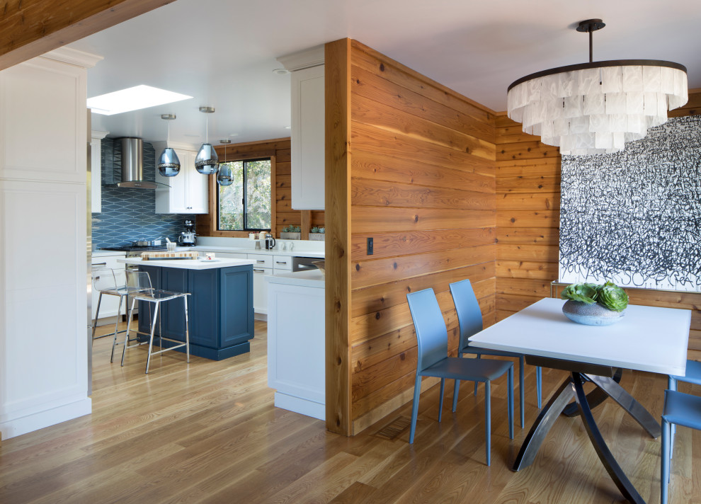 Cette image montre une petite salle à manger ouverte sur la cuisine design en bois avec un mur beige, un sol en bois brun et un sol beige.