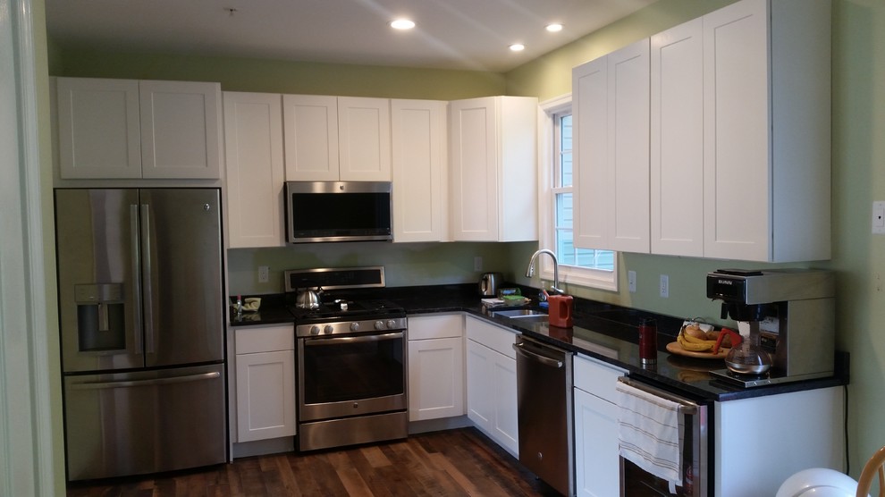 Eat-in kitchen - small transitional l-shaped dark wood floor and brown floor eat-in kitchen idea in Baltimore with a double-bowl sink, shaker cabinets, white cabinets, granite countertops, stainless steel appliances, no island and black countertops