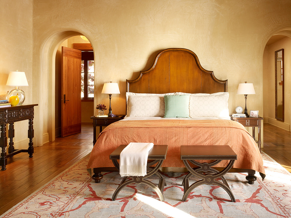 Photo of a mediterranean bedroom in San Francisco with beige walls and dark hardwood floors.