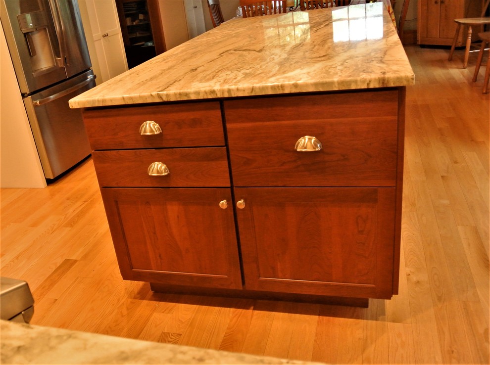 Example of a transitional light wood floor kitchen design in Boston with an undermount sink, shaker cabinets, white cabinets, quartzite countertops, white backsplash, subway tile backsplash, stainless steel appliances and an island