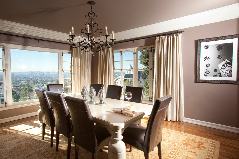 This is an example of a transitional dining room in Los Angeles with brown walls and dark hardwood floors.