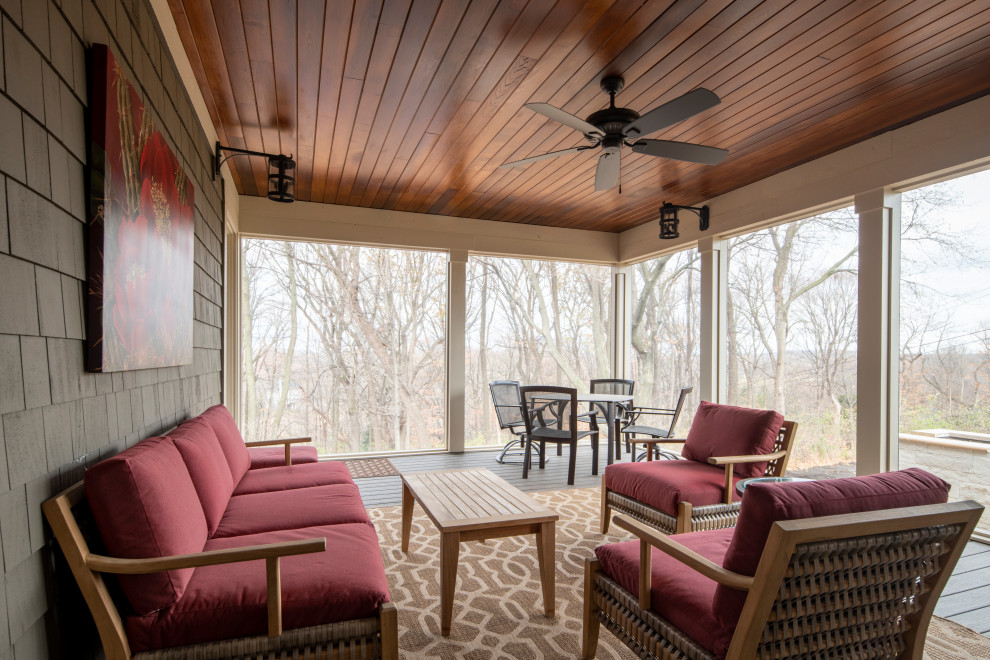 Large elegant screened-in back porch photo in Minneapolis with decking and a roof extension