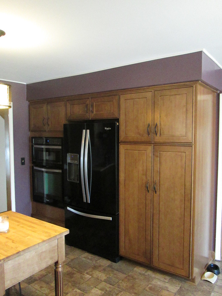 Huge transitional l-shaped vinyl floor eat-in kitchen photo in Detroit with an undermount sink, raised-panel cabinets, medium tone wood cabinets, granite countertops, multicolored backsplash, mosaic tile backsplash, black appliances and an island