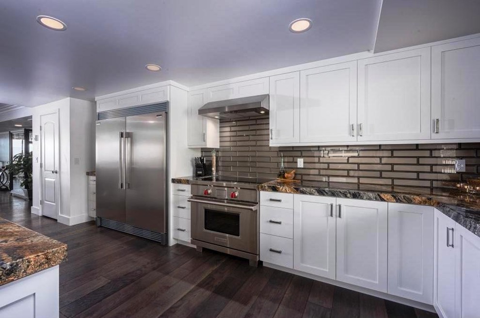 Large contemporary galley eat-in kitchen in Salt Lake City with an undermount sink, shaker cabinets, white cabinets, granite benchtops, metallic splashback, glass tile splashback, stainless steel appliances, dark hardwood floors, a peninsula, brown floor and green benchtop.