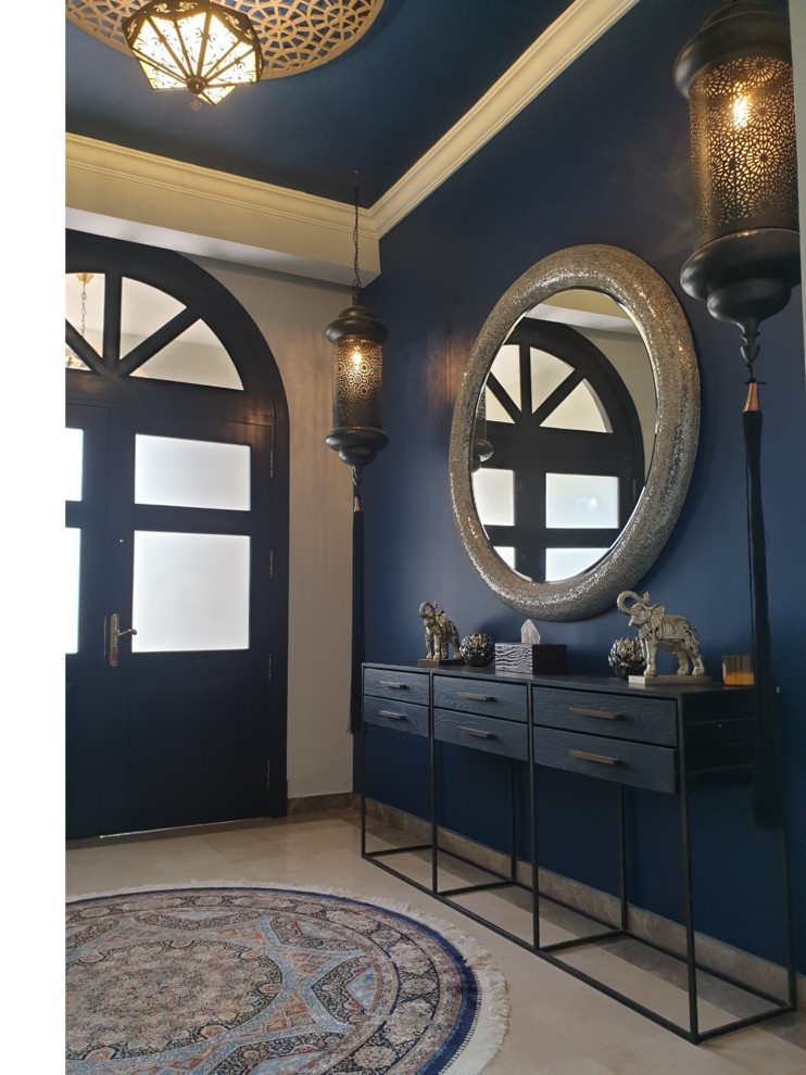 Large eclectic ceramic tile entry hall photo with blue walls and a black front door