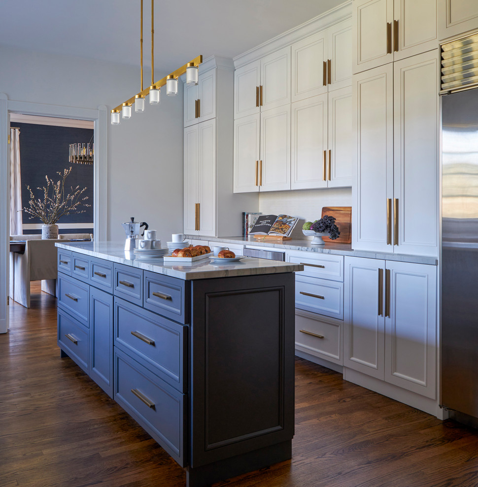 Mid-sized transitional galley medium tone wood floor enclosed kitchen photo in Chicago with a single-bowl sink, recessed-panel cabinets, white cabinets, quartzite countertops, white backsplash, ceramic backsplash, stainless steel appliances, an island and white countertops