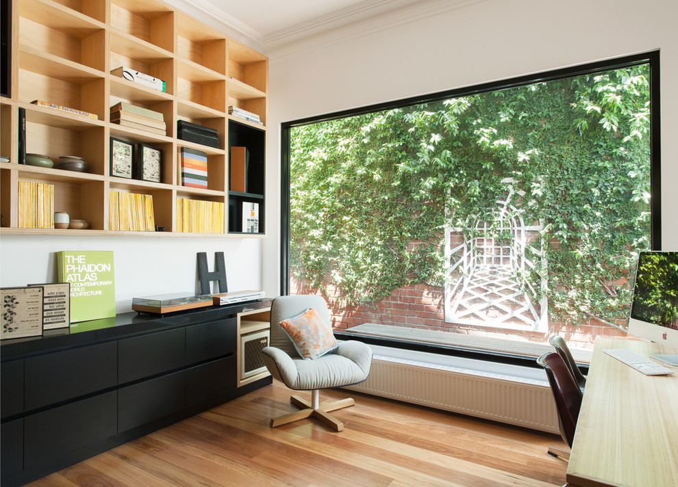 Inspiration for a mid-sized contemporary study room in Melbourne with white walls, medium hardwood floors, no fireplace and a freestanding desk.