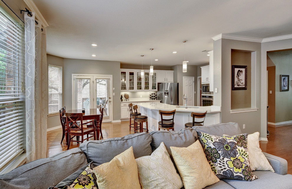 Eat-in kitchen - mid-sized transitional u-shaped eat-in kitchen idea in Austin with an undermount sink, shaker cabinets, white cabinets, quartz countertops, white backsplash, stone slab backsplash, stainless steel appliances and a peninsula