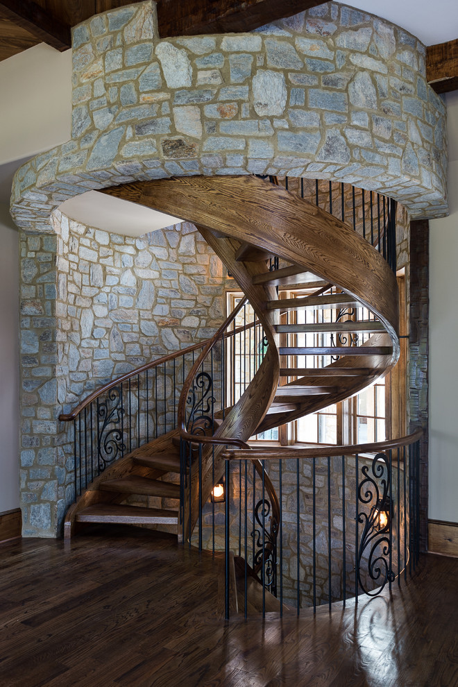 Expansive country wood spiral staircase in Other with open risers.