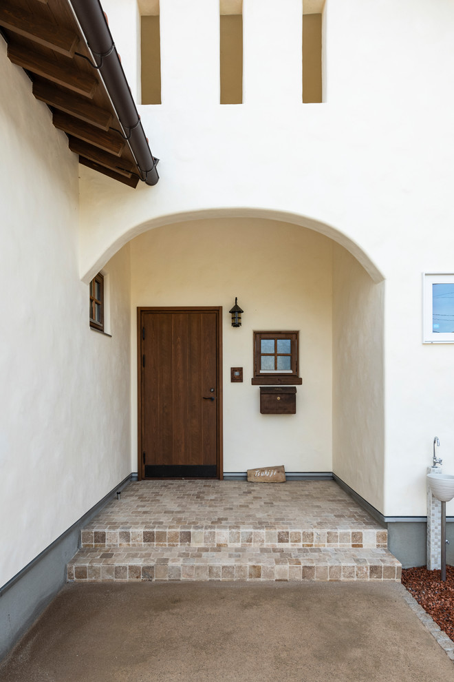 Inspiration for a mid-sized mediterranean front door in Other with beige walls, travertine floors, a single front door, a dark wood front door and beige floor.