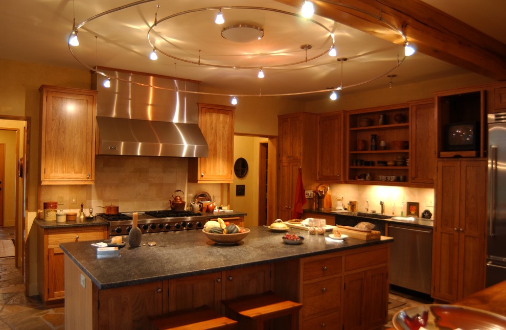 This is an example of a large contemporary l-shaped eat-in kitchen in Chicago with an undermount sink, shaker cabinets, dark wood cabinets, soapstone benchtops, brick splashback, stainless steel appliances and with island.