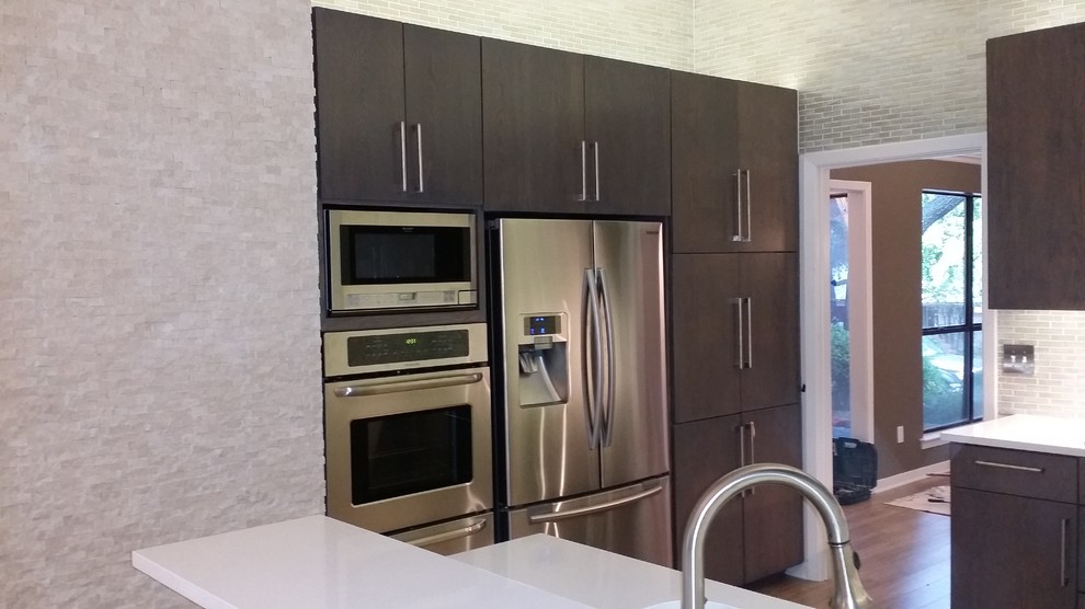 This is an example of a mid-sized contemporary u-shaped kitchen pantry in Dallas with an undermount sink, flat-panel cabinets, dark wood cabinets, wood benchtops, white splashback, glass tile splashback, stainless steel appliances, medium hardwood floors and with island.