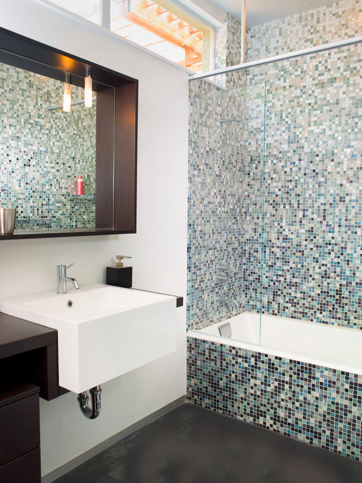 This is an example of a contemporary bathroom in San Francisco with flat-panel cabinets, dark wood cabinets, an alcove tub, a shower/bathtub combo, multi-coloured tile, mosaic tile and white walls.