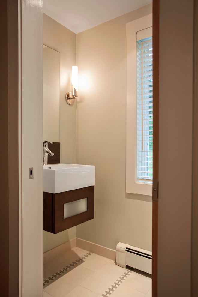 This is an example of a small contemporary master bathroom in Boston with flat-panel cabinets, medium wood cabinets, a freestanding tub, a corner shower, a one-piece toilet, beige tile, porcelain tile, beige walls, porcelain floors, an integrated sink and solid surface benchtops.