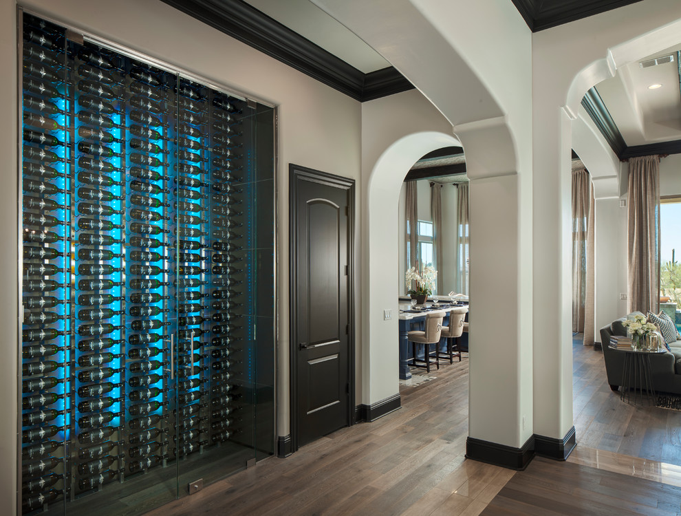 Photo of a mid-sized modern wine cellar in Phoenix with display racks, plywood floors and brown floor.