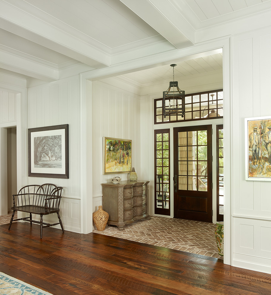 This is an example of a large beach style front door in Other with white walls, a dark wood front door, medium hardwood floors and a single front door.