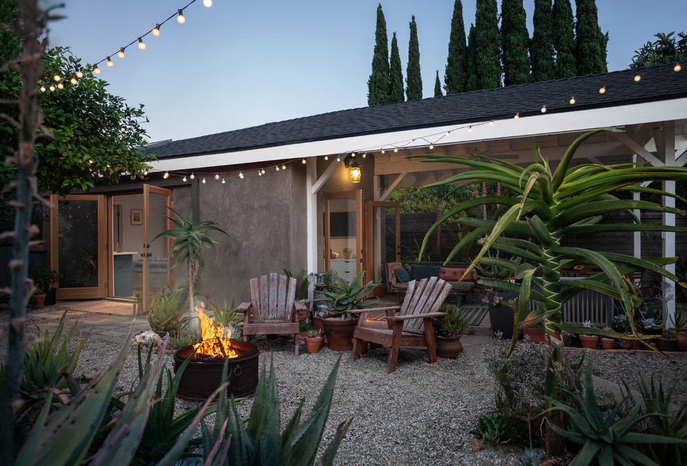 Example of a small beach style backyard gravel patio container garden design in Los Angeles with a roof extension