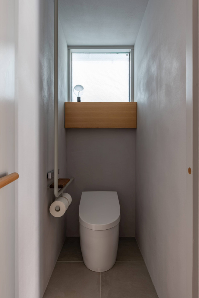 Idee per un piccolo bagno di servizio scandinavo con WC monopezzo, piastrelle grigie, piastrelle in gres porcellanato, pareti grigie, pavimento in gres porcellanato, lavabo da incasso e pavimento grigio