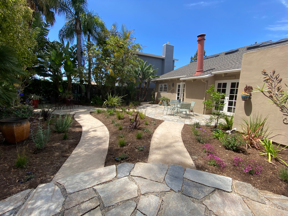 Пример оригинального дизайна: маленький засухоустойчивый сад на заднем дворе в стиле фьюжн с клумбами, полуденной тенью и покрытием из каменной брусчатки для на участке и в саду