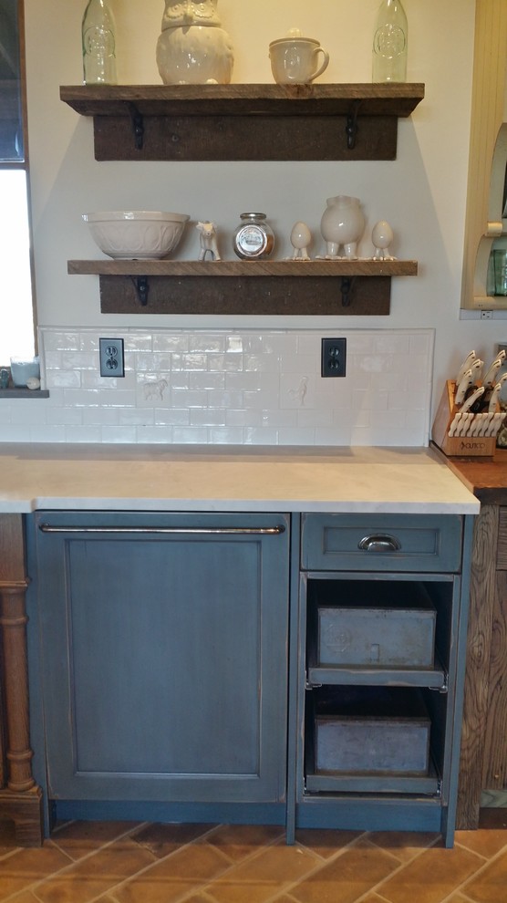 Country kitchen in Denver with a farmhouse sink, white splashback and ceramic floors.