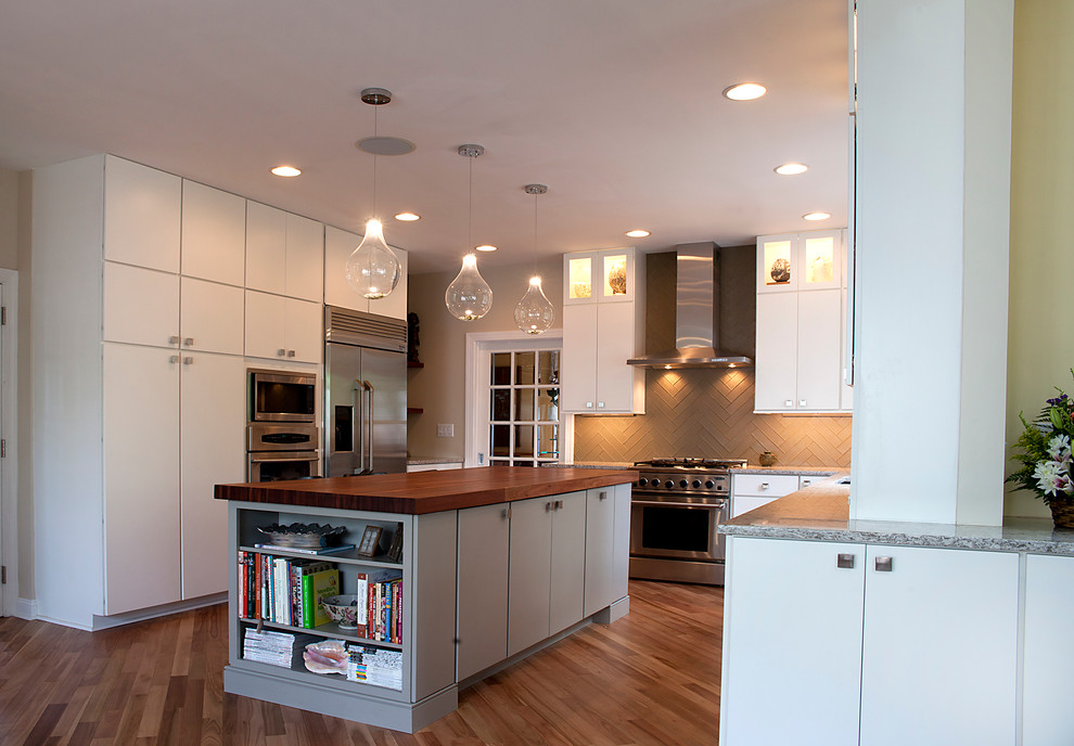 Photo of a mid-sized contemporary u-shaped open plan kitchen in Philadelphia with an undermount sink, flat-panel cabinets, white cabinets, quartz benchtops, grey splashback, glass tile splashback, stainless steel appliances, light hardwood floors and with island.