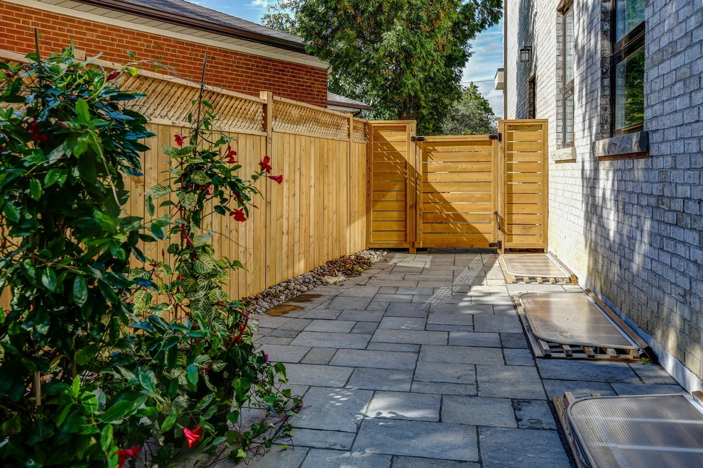 Mid-sized transitional backyard stone and rectangular pool photo in Toronto