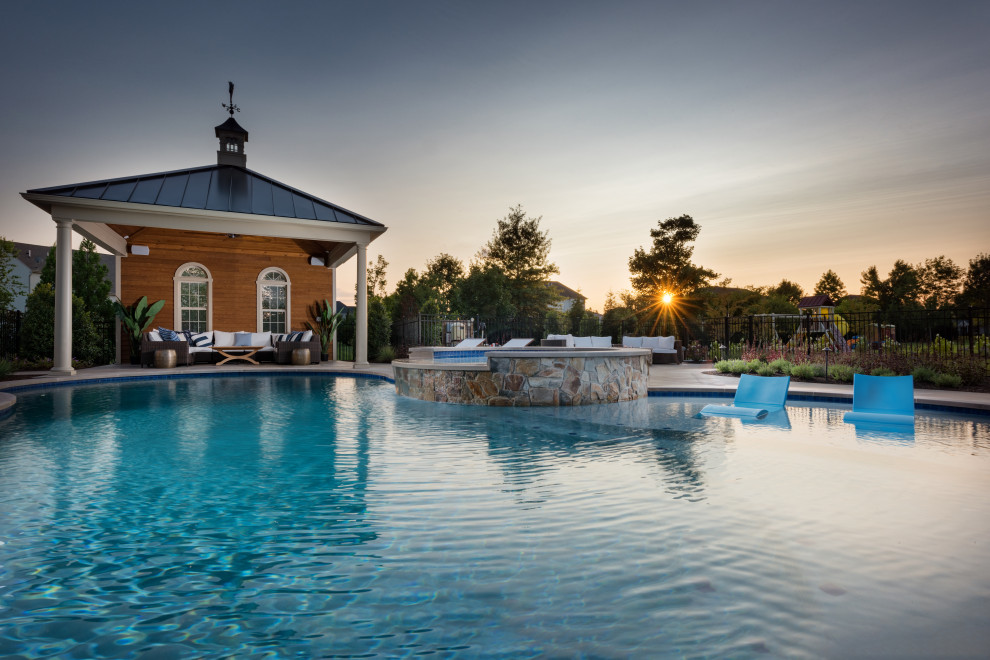 Foto di una grande piscina naturale tradizionale personalizzata dietro casa con paesaggistica bordo piscina e pavimentazioni in pietra naturale