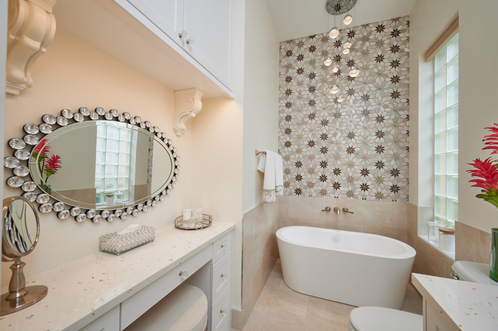 Freestanding bathtub - large transitional master beige tile and porcelain tile porcelain tile, beige floor and single-sink freestanding bathtub idea with shaker cabinets, white cabinets, a two-piece toilet, gray walls, a drop-in sink, quartz countertops, multicolored countertops, a niche and a built-in vanity
