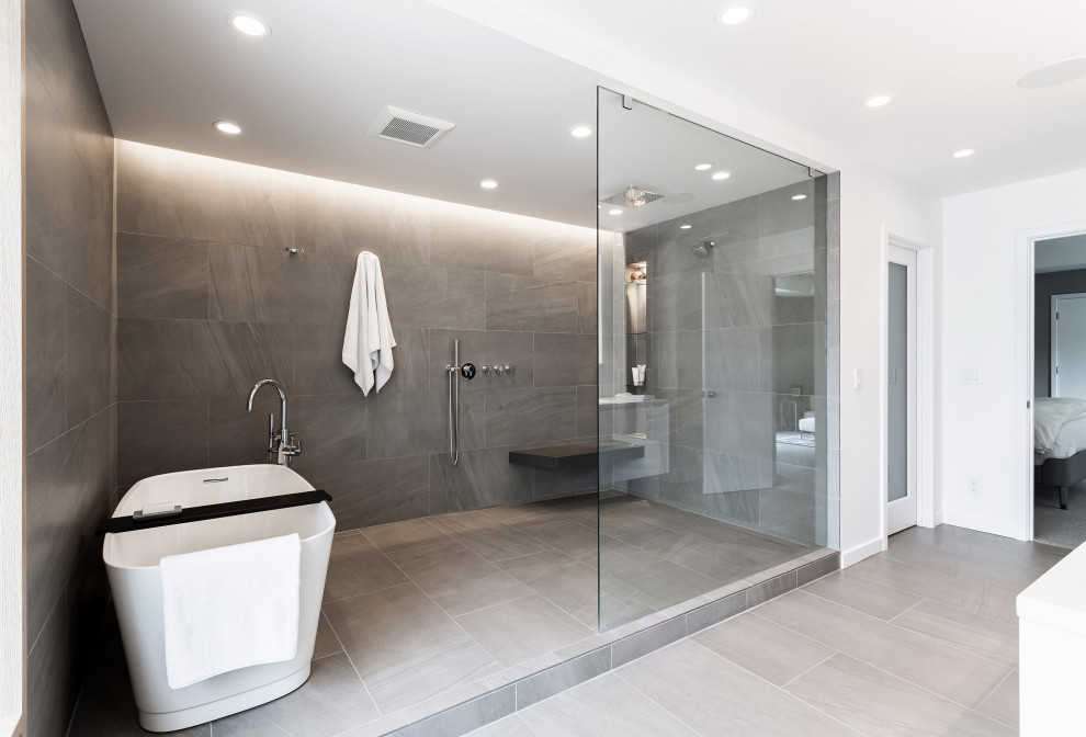 Design ideas for a mid-sized modern master bathroom in Cincinnati with flat-panel cabinets, white cabinets, a freestanding tub, an open shower, gray tile, porcelain tile, white walls, porcelain floors, an undermount sink, solid surface benchtops, grey floor, an open shower, white benchtops, a shower seat, a double vanity and a floating vanity.
