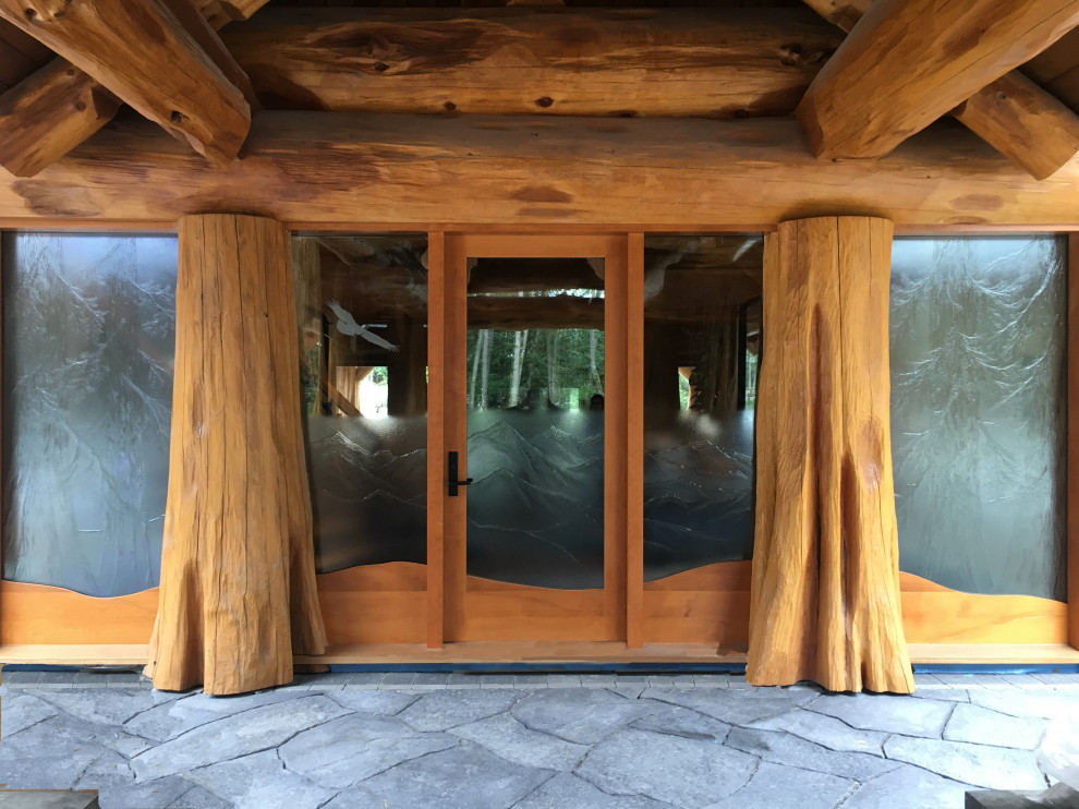 Cette photo montre une très grande porte d'entrée montagne avec une porte simple et une porte en bois clair.