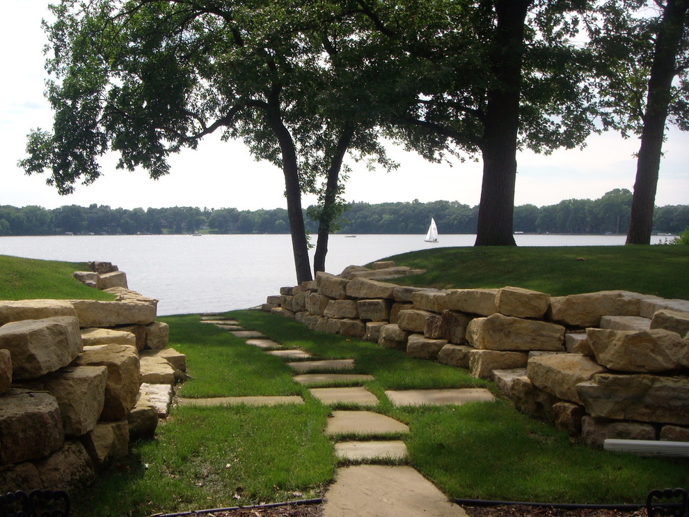 This is an example of a traditional backyard garden in Minneapolis with natural stone pavers.