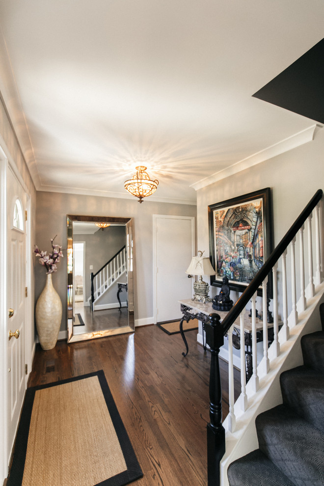 This is an example of a small traditional foyer in DC Metro with grey walls, dark hardwood floors and a single front door.
