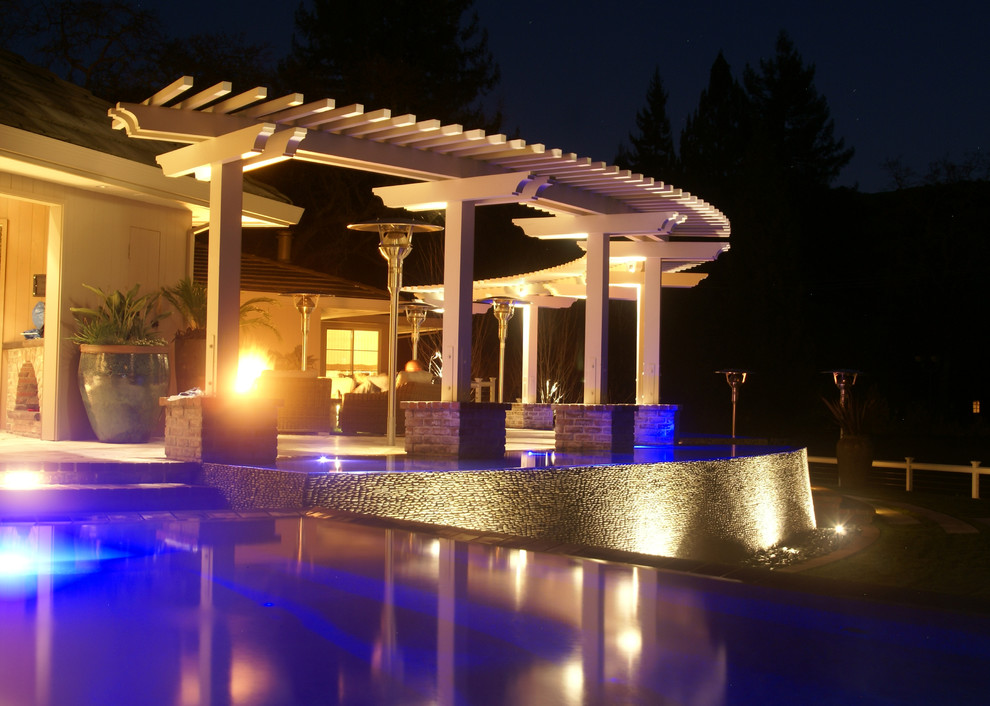 This is an example of a huge modern partial sun backyard stone water fountain landscape in Phoenix for summer.