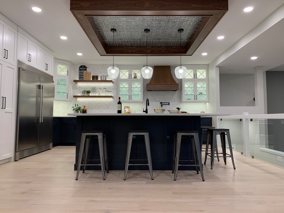 Inspiration for a large transitional light wood floor and coffered ceiling kitchen remodel with an undermount sink, shaker cabinets, white cabinets, quartzite countertops, stainless steel appliances, an island and white countertops