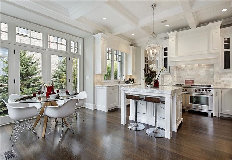 Inspiration for a mid-sized transitional medium tone wood floor and brown floor eat-in kitchen remodel in Chicago with white cabinets, an island, a farmhouse sink, glass-front cabinets, marble countertops, gray backsplash, marble backsplash and stainless steel appliances