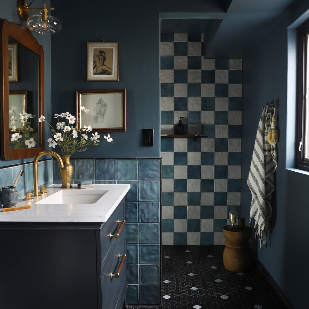 Photo of a transitional bathroom in Minneapolis with flat-panel cabinets, blue cabinets, a curbless shower, blue tile, blue walls, mosaic tile floors, an undermount sink, black floor, an open shower, white benchtops, a single vanity and a freestanding vanity.