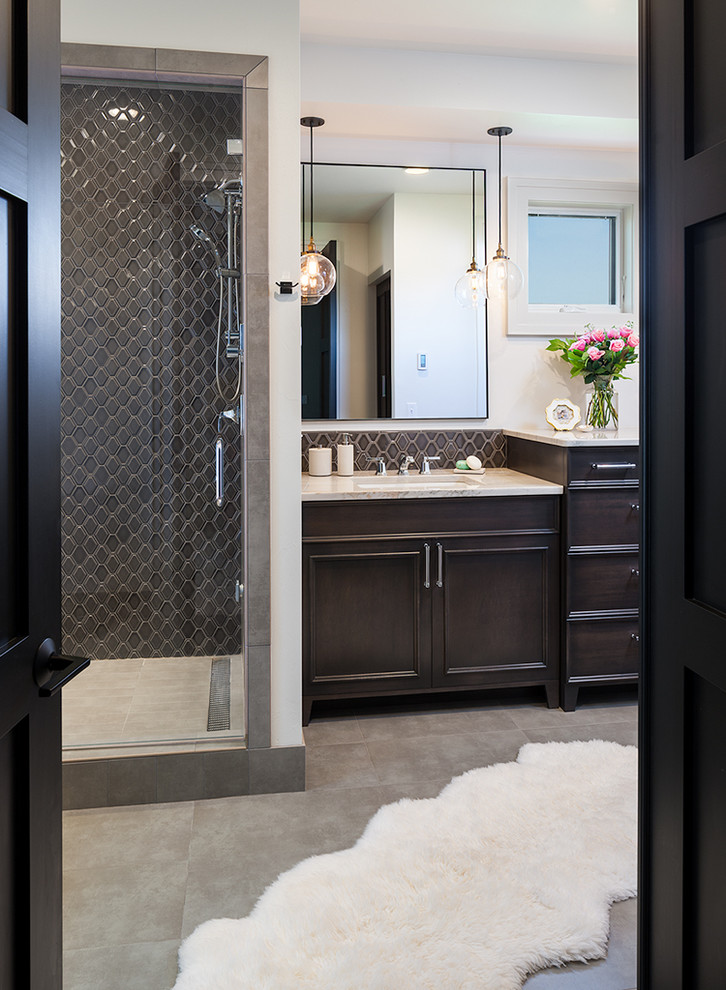 Mid-sized transitional master bathroom in Other with a drop-in sink, furniture-like cabinets, brown cabinets, a freestanding tub, a two-piece toilet, gray tile, porcelain tile, grey walls and porcelain floors.