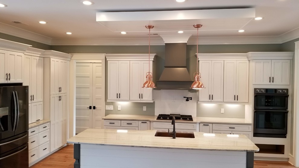 Mid-sized transitional l-shaped medium tone wood floor and brown floor kitchen photo with a farmhouse sink, stainless steel appliances, an island and white cabinets
