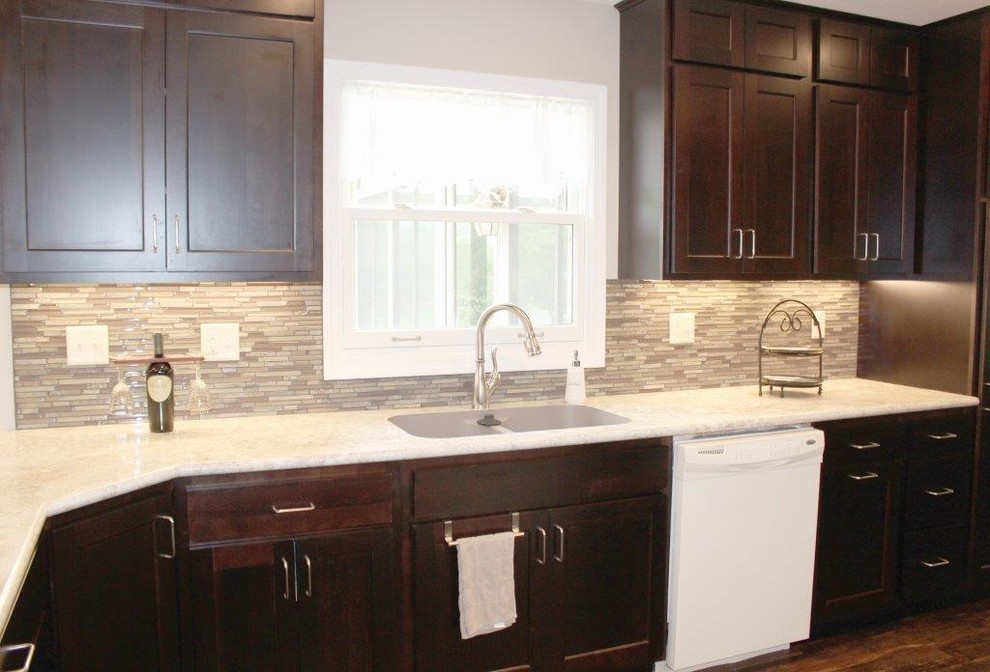 Example of a mid-sized transitional l-shaped vinyl floor and brown floor eat-in kitchen design in Cedar Rapids with a double-bowl sink, laminate countertops, a peninsula, shaker cabinets, dark wood cabinets, beige backsplash, matchstick tile backsplash and white appliances