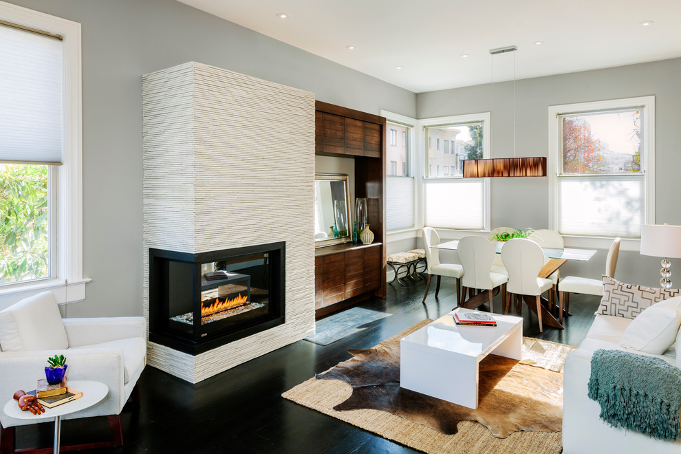 Inspiration for a contemporary formal open concept living room in San Francisco with a two-sided fireplace, grey walls, dark hardwood floors, a tile fireplace surround, a built-in media wall and black floor.