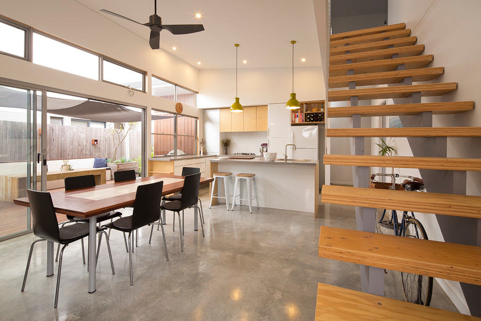 Photo of a small contemporary kitchen/dining combo in Perth with white walls and concrete floors.