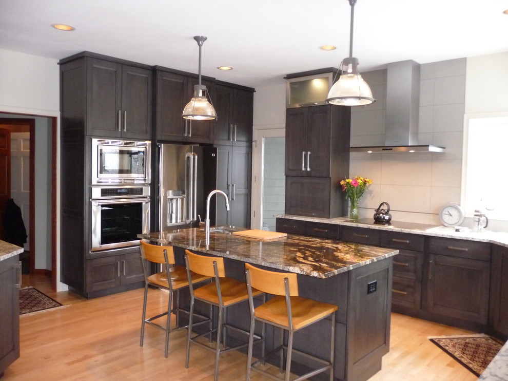 Eat-in kitchen - large transitional u-shaped light wood floor eat-in kitchen idea in Milwaukee with an undermount sink, flat-panel cabinets, gray cabinets, granite countertops, white backsplash, porcelain backsplash, stainless steel appliances and an island
